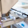 Adapter tamborków Happy Japan One Touch FRA23A00 do hafciarki – dłoń przy mechanizmie mocowania adaptera.