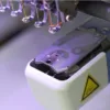 Wskaźnik laserowy do hafciarki Happy HCR – plamka lasera na polu pracy pod głowicą.